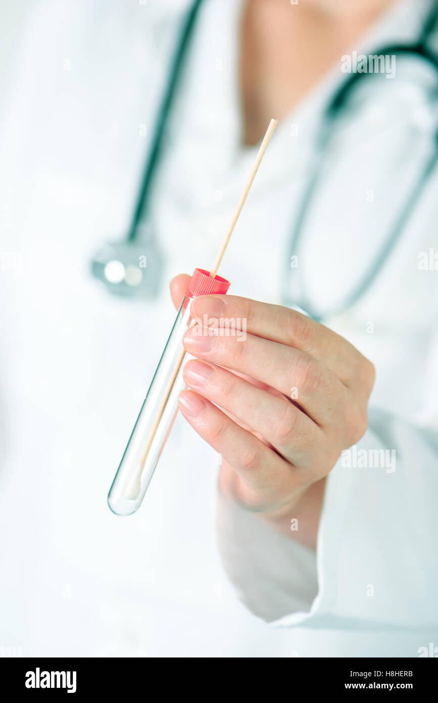 Weibliche Labor-Spezialist hält Reagenzglas mit Wattestäbchen, medizinische Wissenschaft professionelle Aufnahme Probe für Laboranalysen. Stockfoto