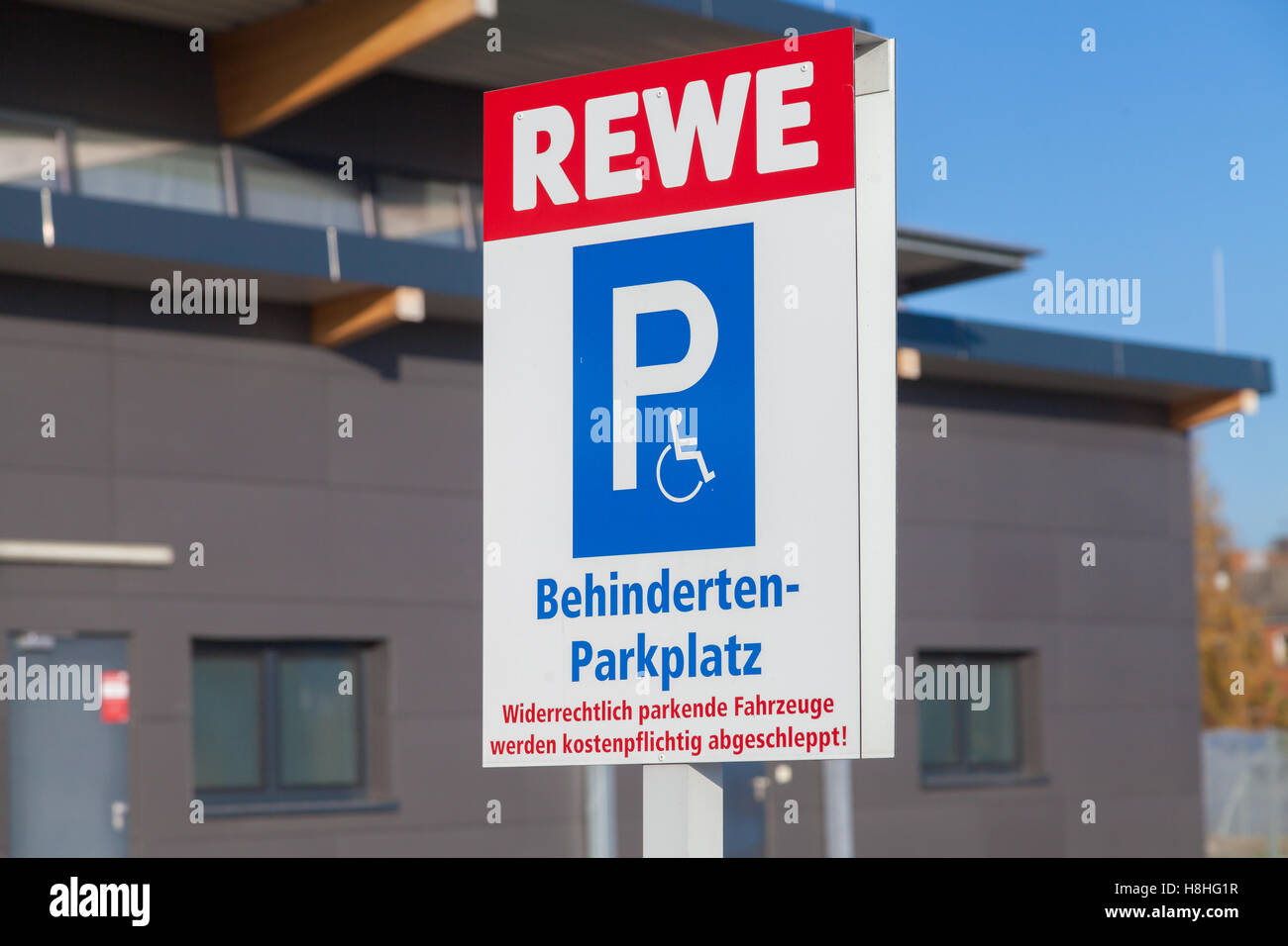 BURG / Deutschland - 13. November 2016: Behindertenparkplatz (Behindertenparkplatz) Zeichen auf dem Parkplatz vom Supermarkt REWE. Stockfoto