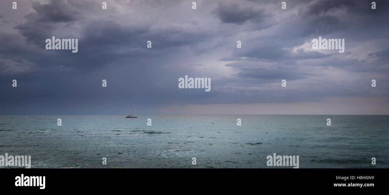 Segelboot auf hoher See und ein Sturm nähert, dramatische Himmel, ruhiger See Stockfoto