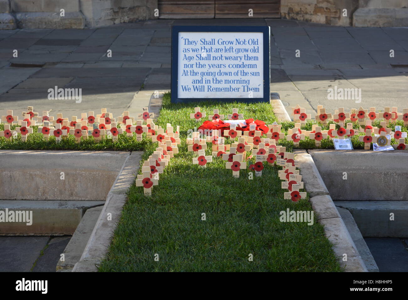 Rote Mohnblumen in ein Kreuz außerhalb Bath Abbey am Tag des Waffenstillstands, 11 November. Stockfoto