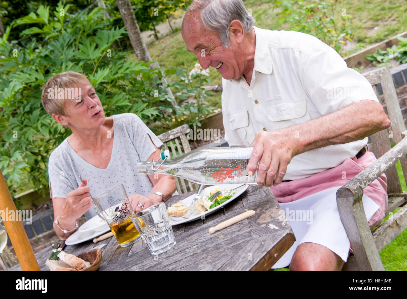 ältere Leute genießen Mittagessen im Pub Garten mit Marken-Wasser rote Löwe Freehouse Wiltshire Stockfoto