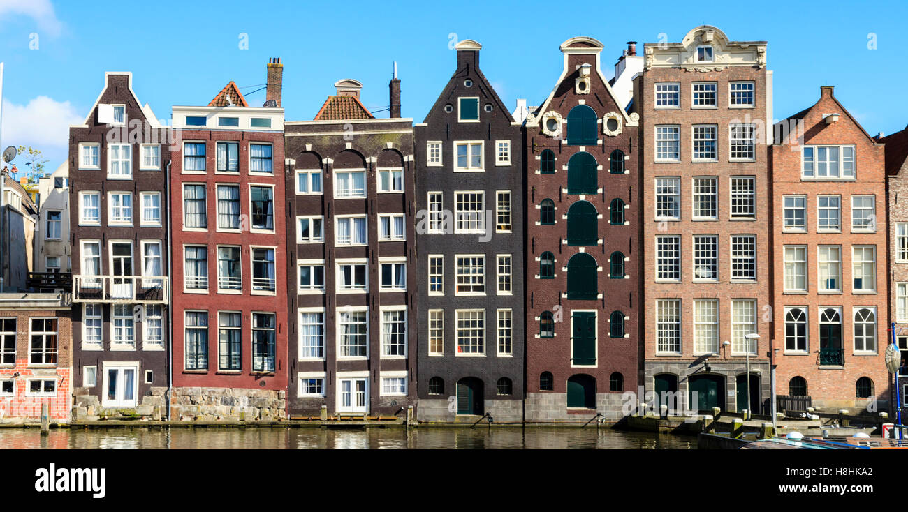 Die berühmten Häuser säumen den Rand des Damrak Kanal-Becken, Amsterdam, Niederlande Stockfoto