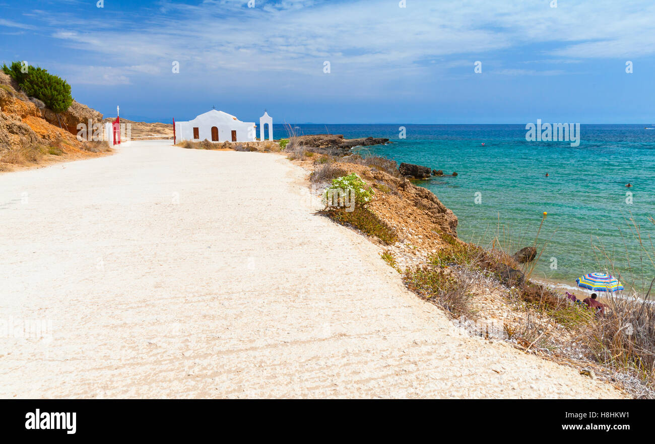 Küstenlandschaft der Insel Zakynthos, Griechenland. Straße am Strand von Agios Nikolaos. Kleine weiße orthodoxe Kirche Stockfoto