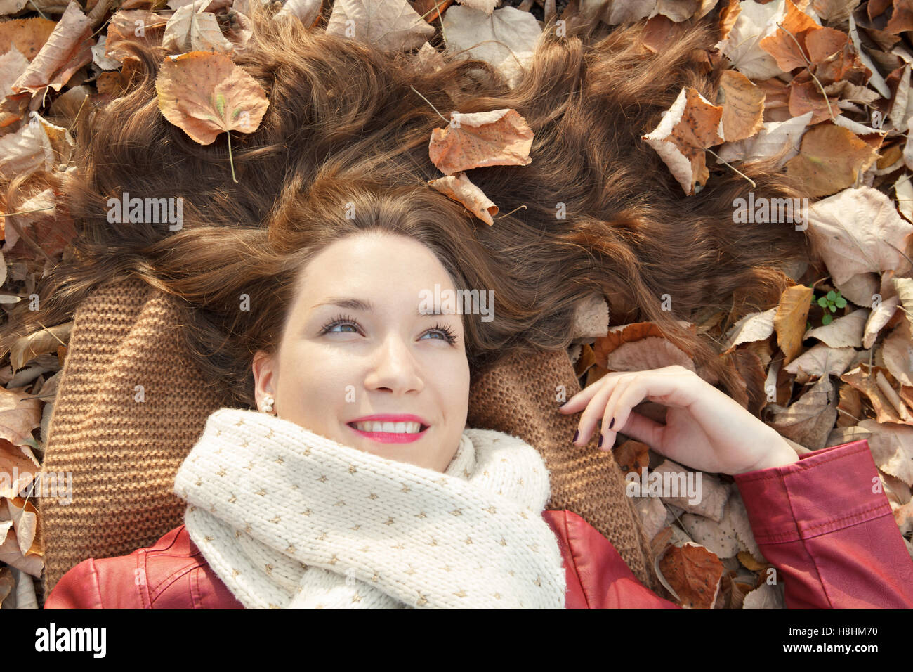 Junge Frau liegt auf gefallenen Herbst Blätter Porträt Stockfoto