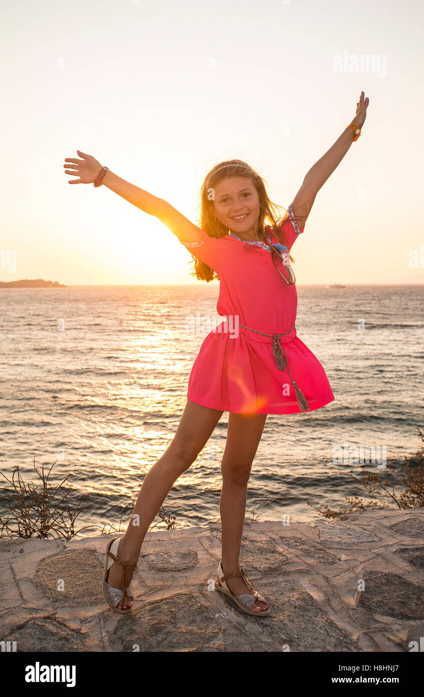 Fröhliches junges Mädchen bei Sonnenuntergang Stockfoto