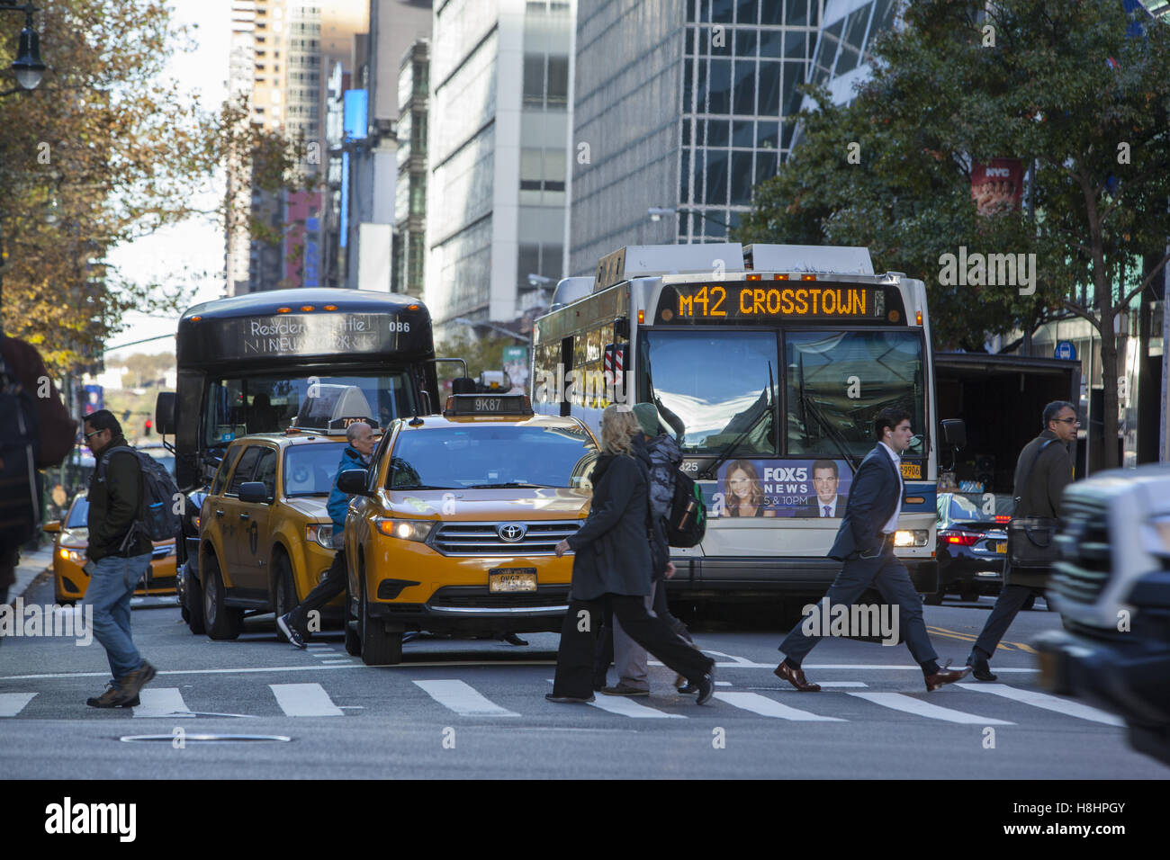 Menschen überqueren 42nd Straße vor der crosstown Verkehr während der morgendlichen Rushhour in New York City. Stockfoto