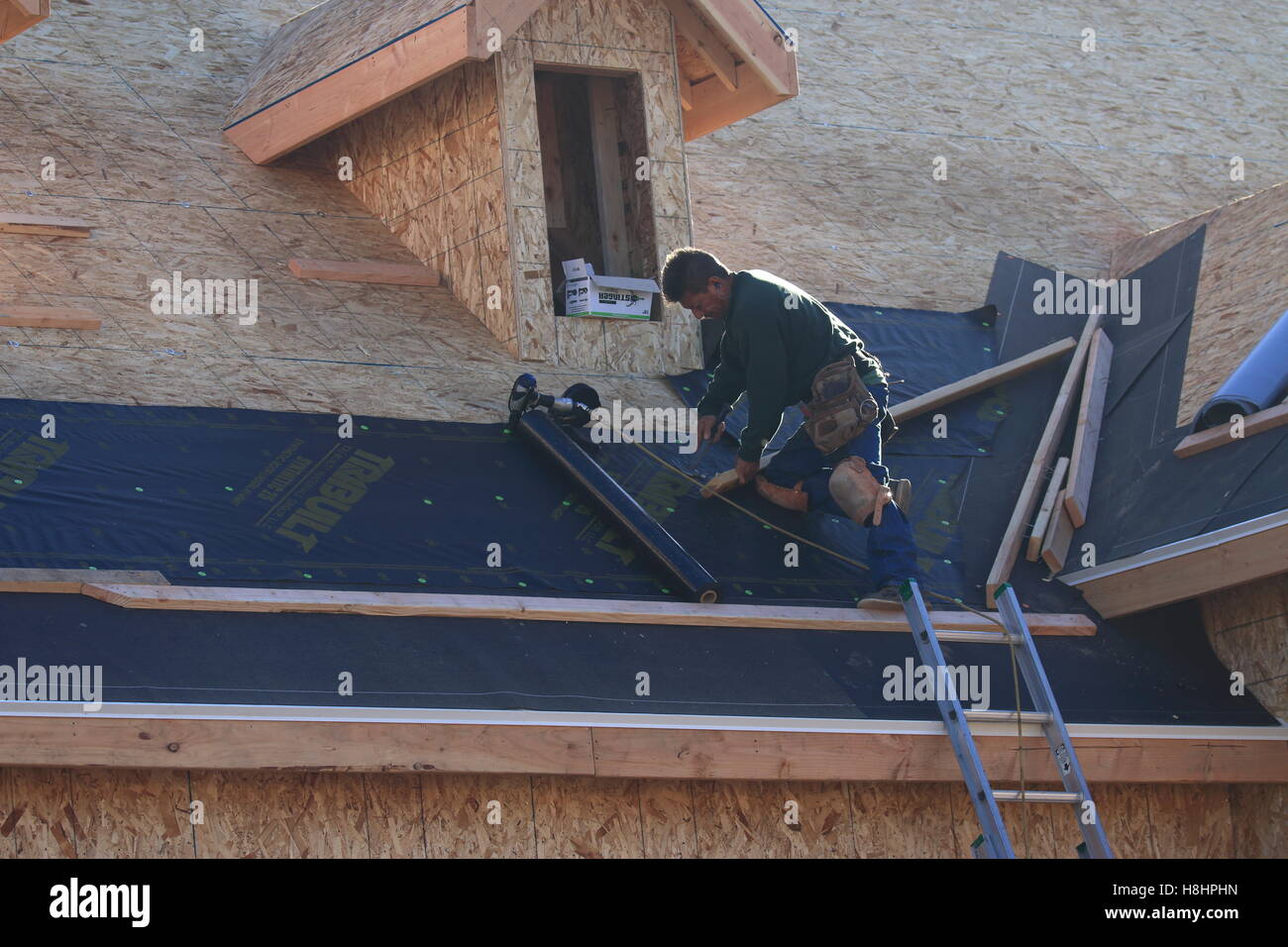 Mann Dachdecker Festlegung Teerpappe auf ein neues Dach Stockfoto