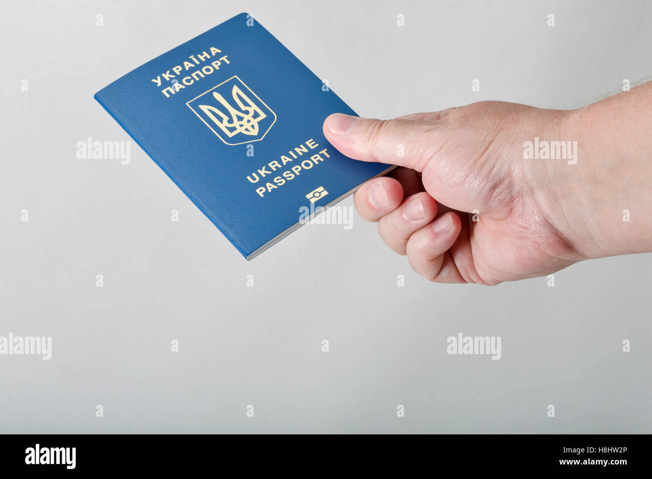 Hand, die ukrainischen biometrischen Pass vor weißem Hintergrund Closeup mit Textfreiraum Stockfoto