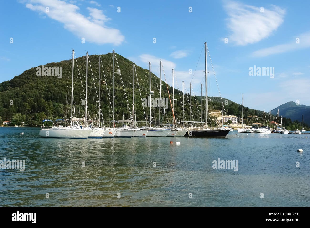 Nidri, Griechenland, 11. Mai 2013: Landschaft mit blauen Hafen, grüne Küste und Yachten im Ionischen Meer, Griechenland. Stockfoto