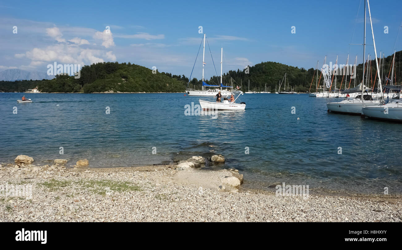 Nidri, Griechenland, 11. Mai 2013: Landschaft mit blauen Hafen, grüne Küste, Yachten und Fischerboot im Ionischen Meer, Griechenland. Stockfoto