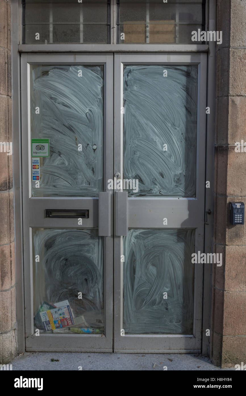 Closed Shop Räumlichkeiten - nicht abgeholte Post und Prospekte sammeln hinter Schaufenster. Tod von der High Street Metapher. Stockfoto