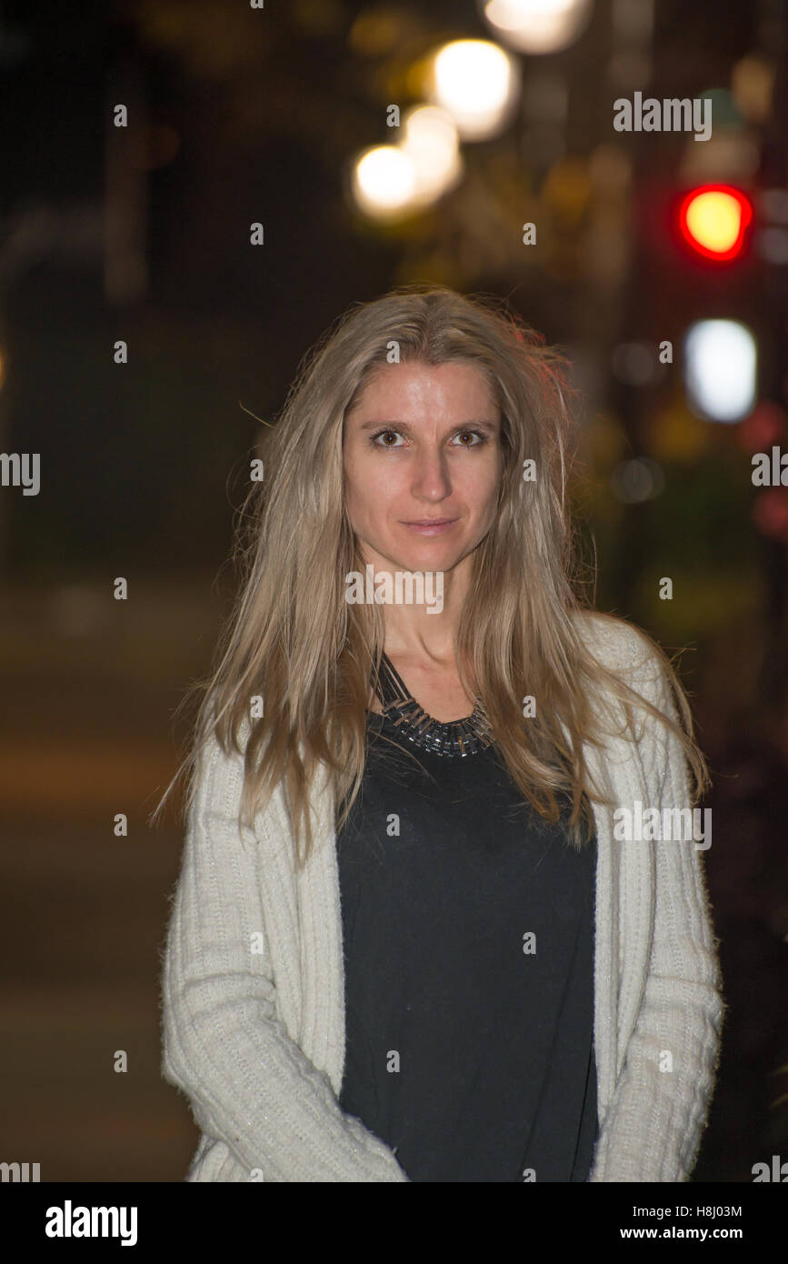 Attraktive blonde Frau in die Stadt bei Nacht mit unscharfen Hintergrund Stockfoto
