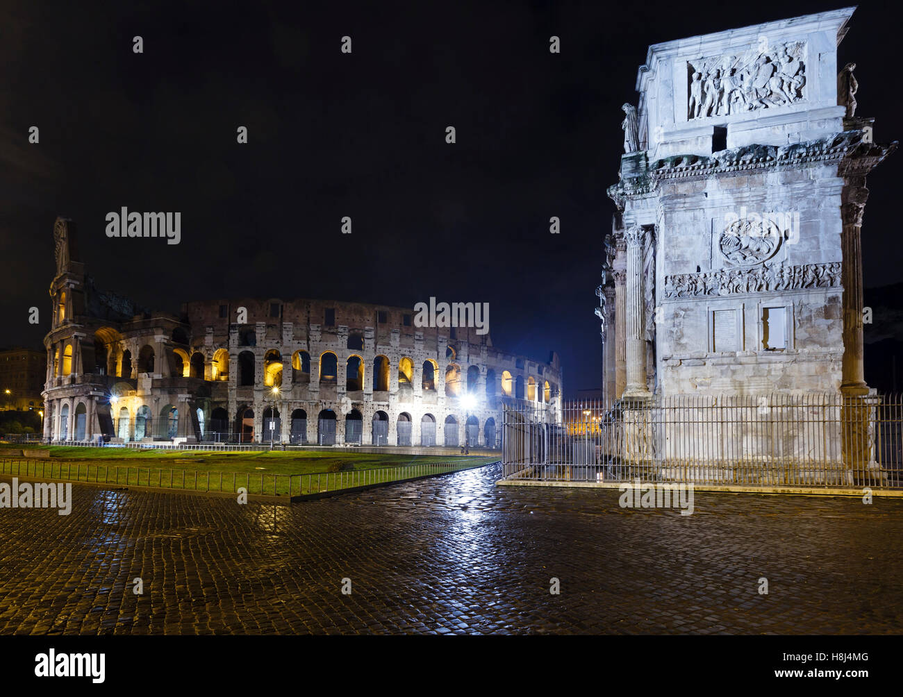 Kolosseum und Constantine Arch Nachtansicht in Rom, Italien (mit einigen leichten Fackeln) Stockfoto