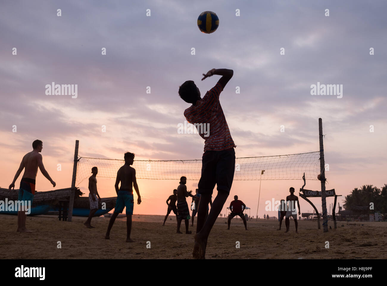 Beachvolleyball Spieler Silhouette bei Sonnenuntergang. Stockfoto