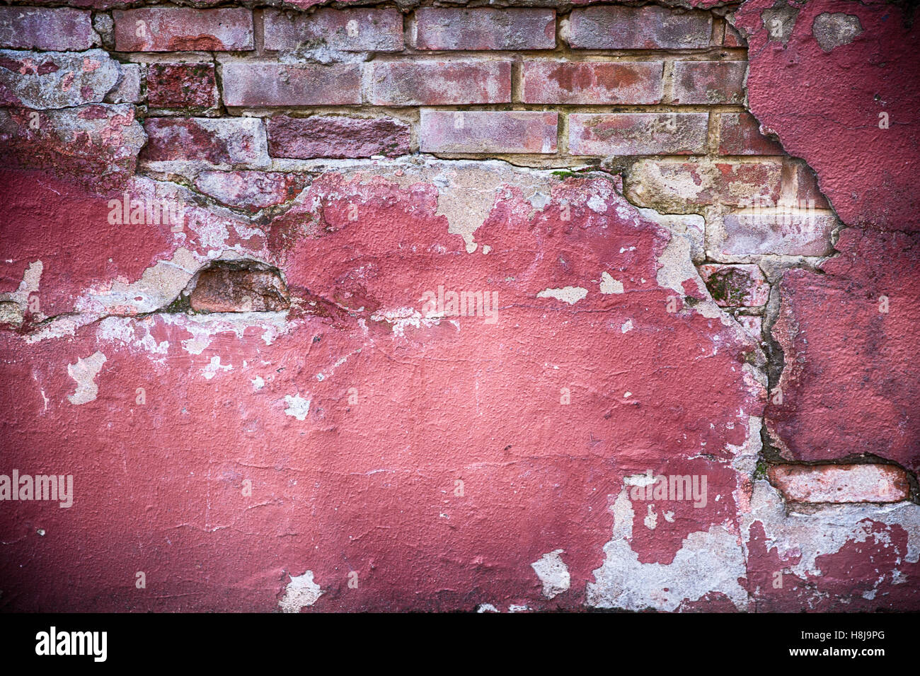 Verfallende Wandbeschaffenheit Grunge. Rote Farbe und Backstein mit Gips herunterfallen Stockfoto