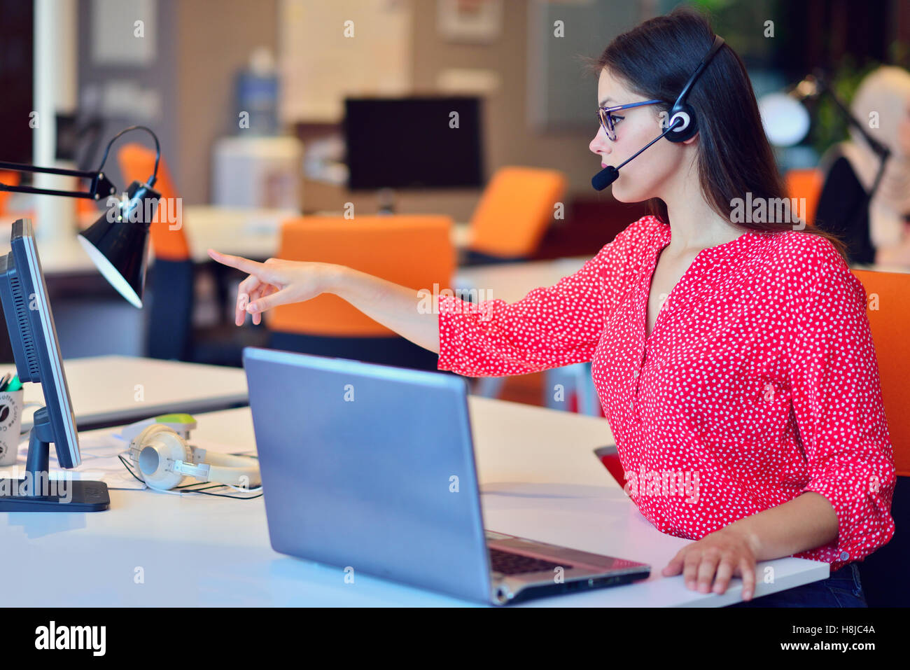 Junge Frau, die Arbeit in Callcenter Stockfoto