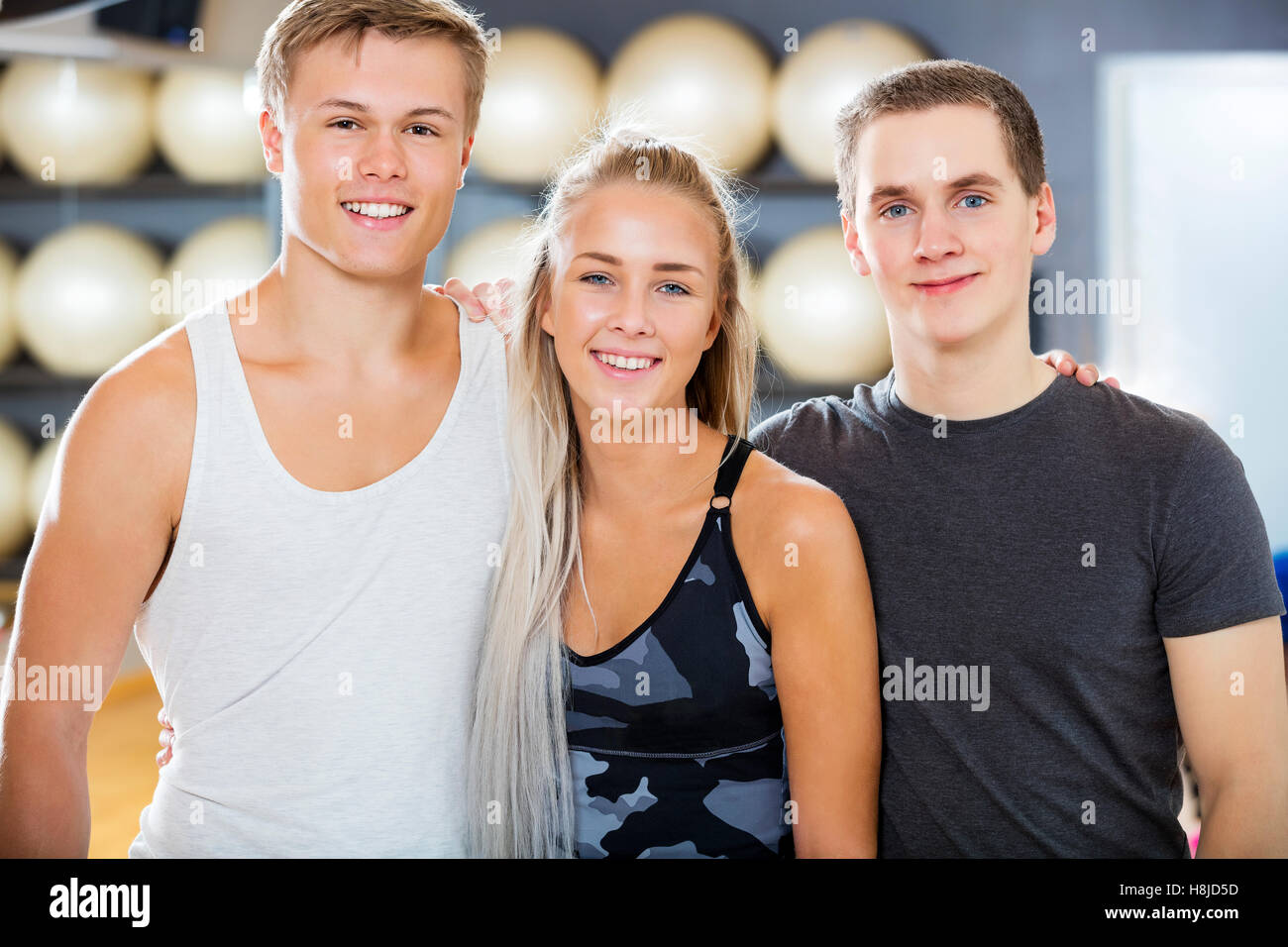 Zuversichtlich, männliche und weibliche Freunde lächelnd In Fitness-Studio Stockfoto