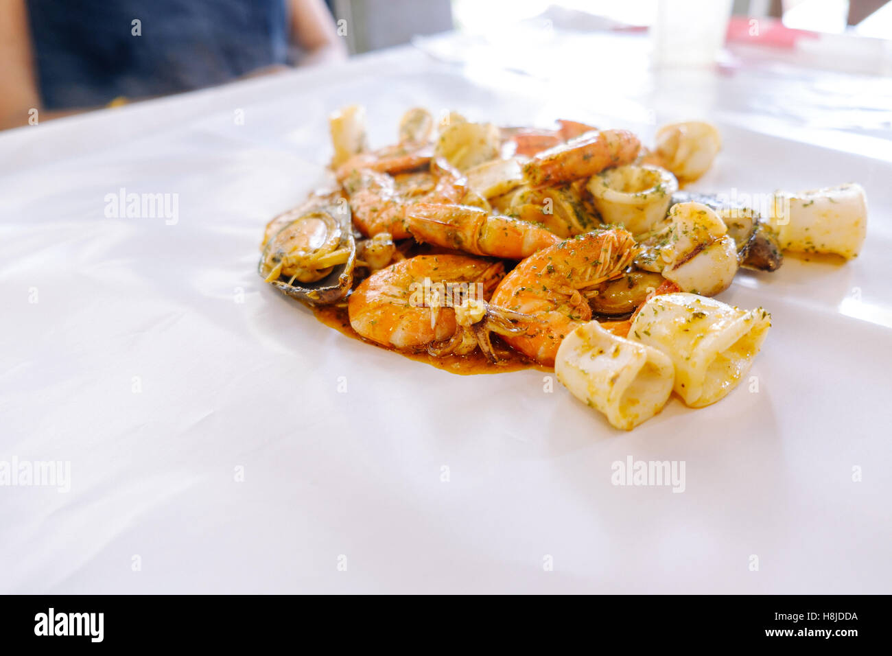 Krustentier Meeresfrüchte mit Muscheln, Austern und Garnelen am Tisch und weiß Wachspapier, Tiefenschärfe, Essen Hintergrund. Stockfoto