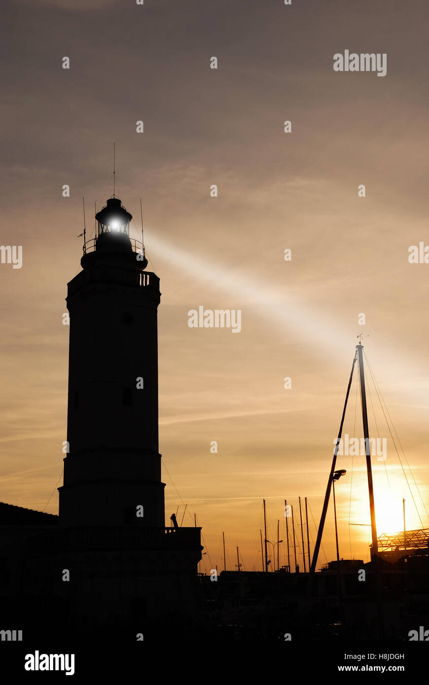 Leuchtturm bei Sonnenuntergang auf dem Port mit bewölktem Himmel Stockfoto