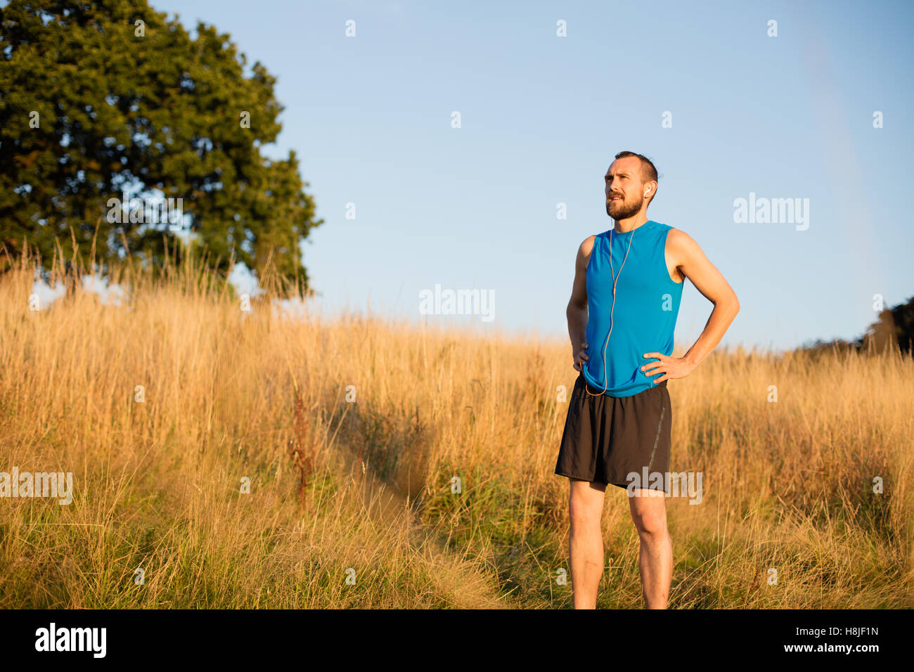 Junger sportlicher Mann, ruhen Sie sich nach einem Lauf im park Stockfoto