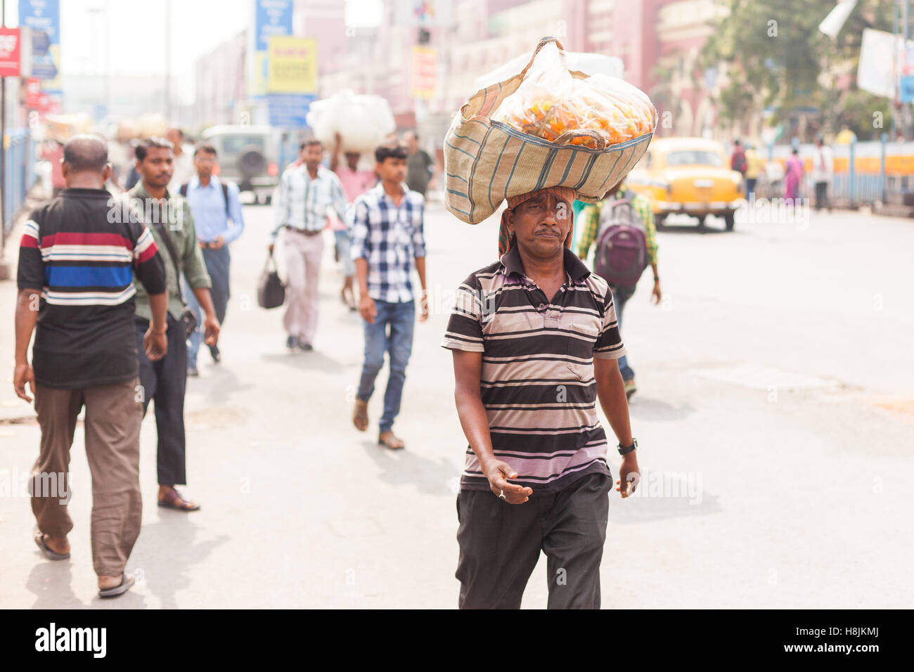 KOLKATA, Indien - 22. Oktober 2016: ein Mann trägt einen Korb mit Blumen balanciert auf dem Kopf in der Nähe von Howrah Station am 22. Oktober 2016 in Stockfoto