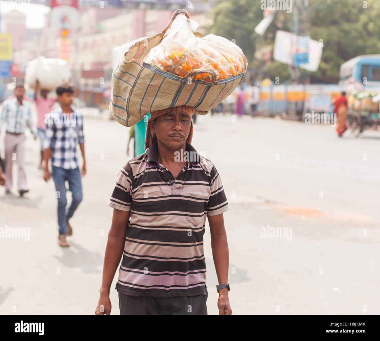 KOLKATA, Indien - 22. Oktober 2016: ein Mann trägt einen Korb mit Blumen balanciert auf dem Kopf in der Nähe von Howrah Station am 22. Oktober 2016 in Stockfoto