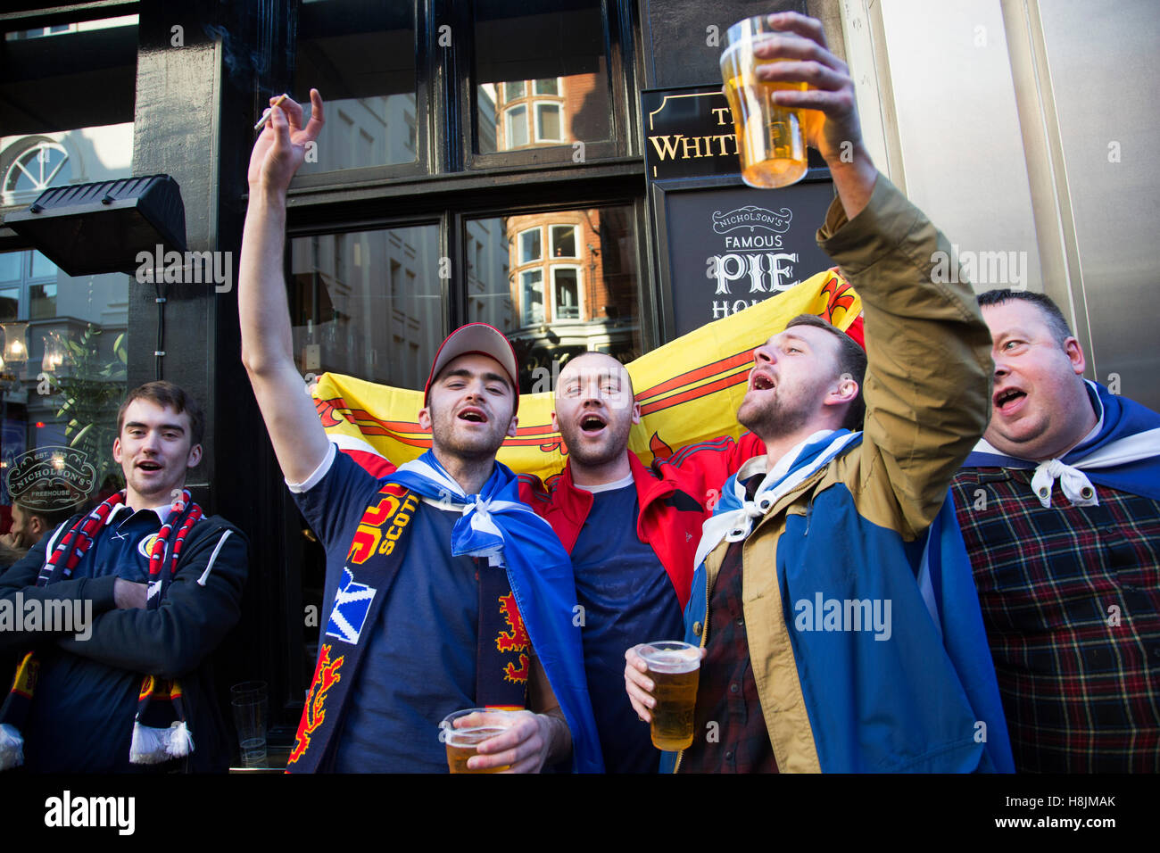 Schottland-Fans in fröhliche Stimmung trinken und singen gemeinsam in Covent Garden vor ihr Fußballspiel, England Vs Schottland, WM-Qualifikation-Gruppe Bühne am 11. November 2016 in London, Vereinigtes Königreich. Home International Rivalität zwischen ihren jeweiligen Nationalmannschaften ist die älteste internationale Leuchte der Welt, im Jahre 1872 zum ersten Mal gespielt. Stockfoto