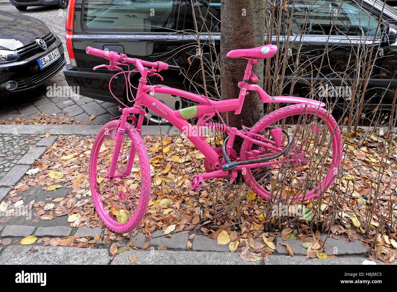 Rosa lackiert Fahrrad an einen Baum in Prenzlauer Berg Straße, Berlin KATHY DEWITT gesperrt Stockfoto