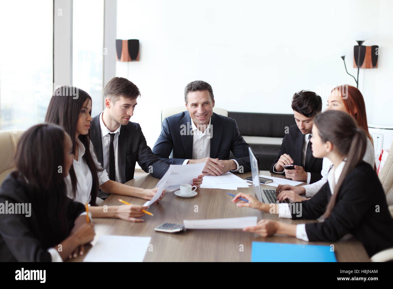 Business-Meeting der unterschiedlichsten Menschen rund um den Tisch Stockfoto
