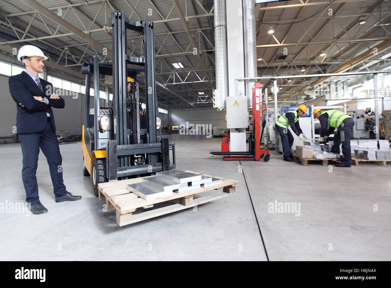Manager und Arbeitnehmer, die mit Blech Hebevorrichtung in CNC-Fabrik Stockfoto Manager und Arbeitnehmer, die mit Blech Hebevorrichtung in CNC-Fabrik Stockfoto