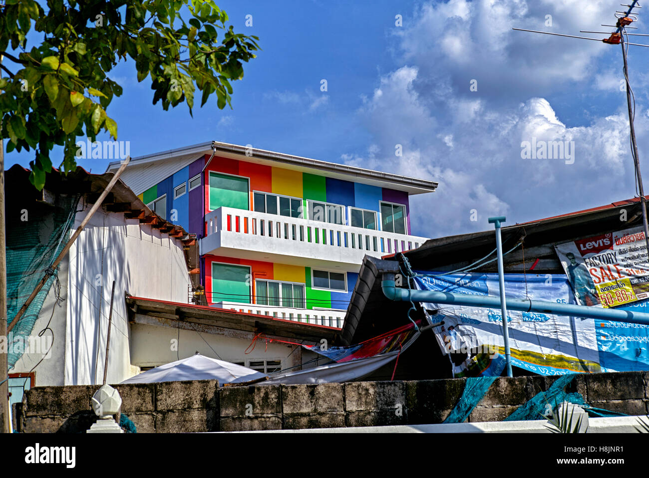 Mehrfarbig lackiertes Gebäude in einer heruntergekommenen Umgebung, das das Konzept von Neu und Alt bietet. Thailand S. E. Asien Stockfoto