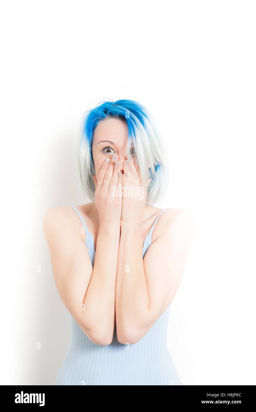 Junge schöne blaue Haare alternative Hipster Frau betäubt Ausdruck Blick in die Kamera mit der Hand auf Gesicht isoliert auf weiss Stockfoto
