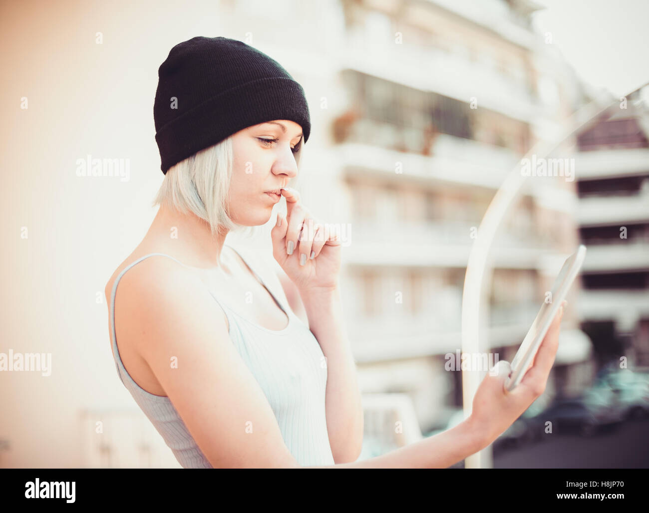 Junge hübsche Mädchen Hipster Stil mit wi-Fi-Tablet-Gerät Denken auf städtischen Hintergrund Stockfoto