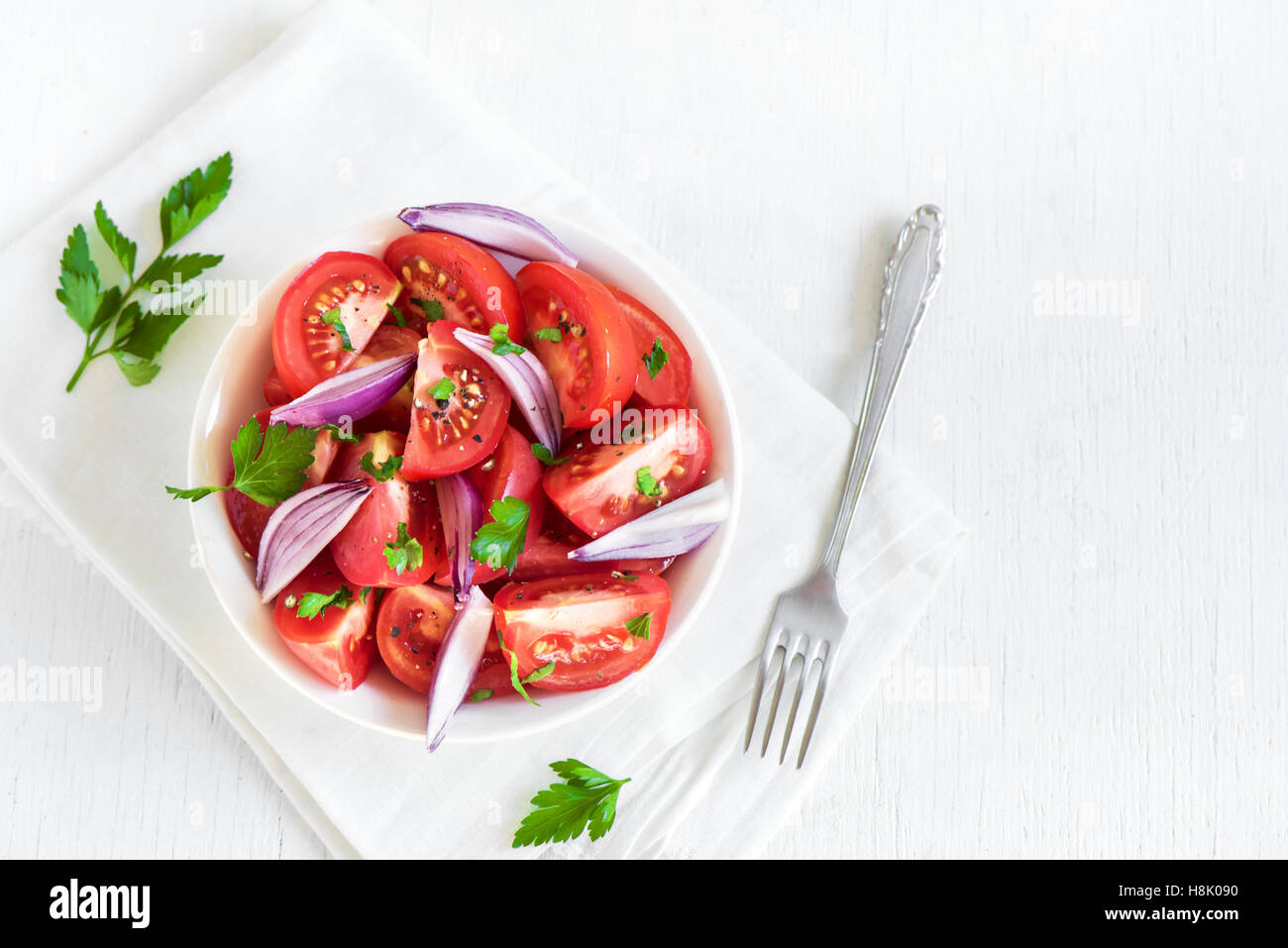 Tomatensalat mit Zwiebeln, Petersilie und Pfeffer in Schüssel - gesunde vegetarische vegane Lebensmittel Vorspeise Stockfoto