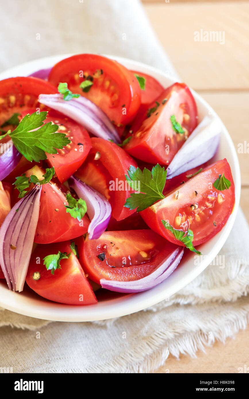 Tomatensalat mit Zwiebeln, Petersilie und Pfeffer in Schüssel - gesunde vegetarische vegane Lebensmittel Vorspeise Stockfoto