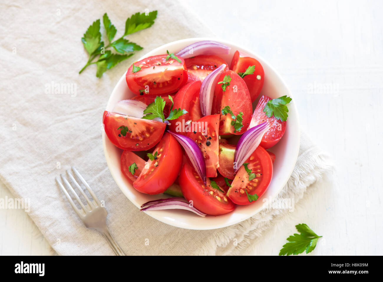 Tomatensalat mit Zwiebeln, Petersilie und Pfeffer in Schüssel - gesunde vegetarische vegane Lebensmittel Vorspeise Stockfoto