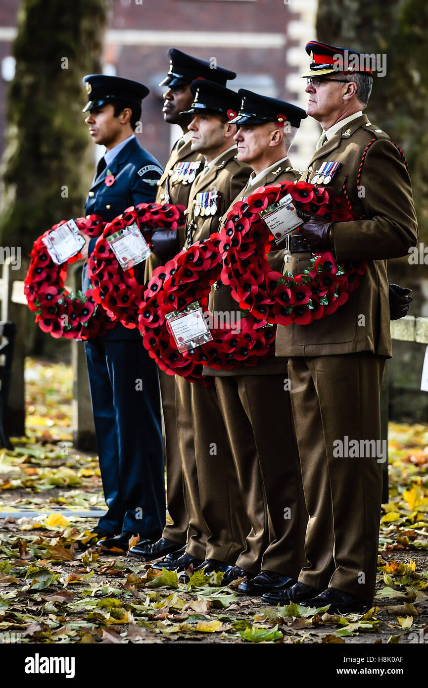 Mitglieder des Militärs halten Mohn Kränze während einer Erinnerung Sonntagsgottesdienst in Queen Square, Bristol, statt zu Ehren für Mitglieder der Streitkräfte, die in größeren Konflikten gestorben sind. Stockfoto