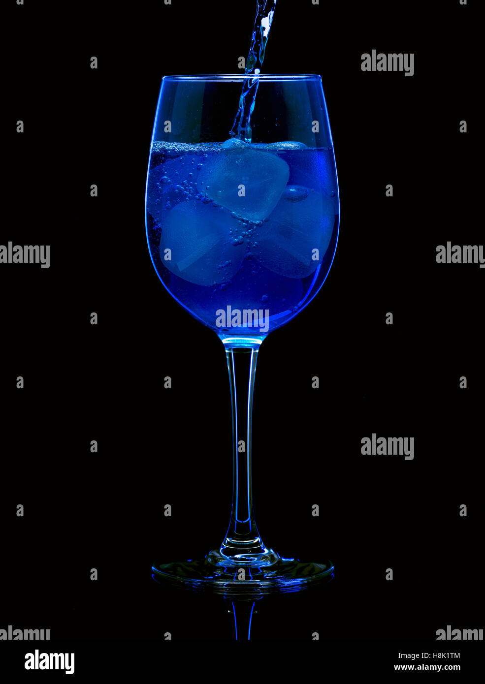 blaue Wasser in ein Glas gegossen Stockfoto