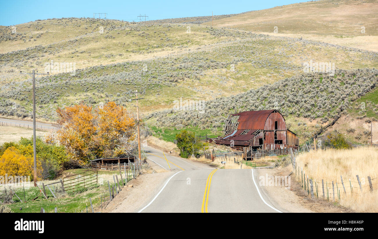 Landstraße und ikonischen verrosteten alten Scheune mit Herbst Bäume Stockfoto