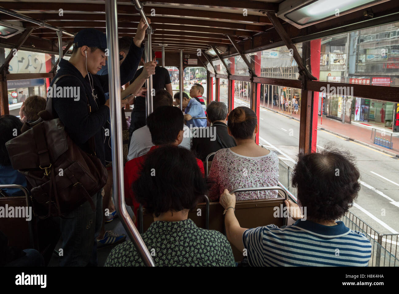 Menschen auf dem Oberdeck im Inneren ein Doppelstock-Straßenbahn (auch bekannt als Ding Ding) in Hong Kong, China. Stockfoto