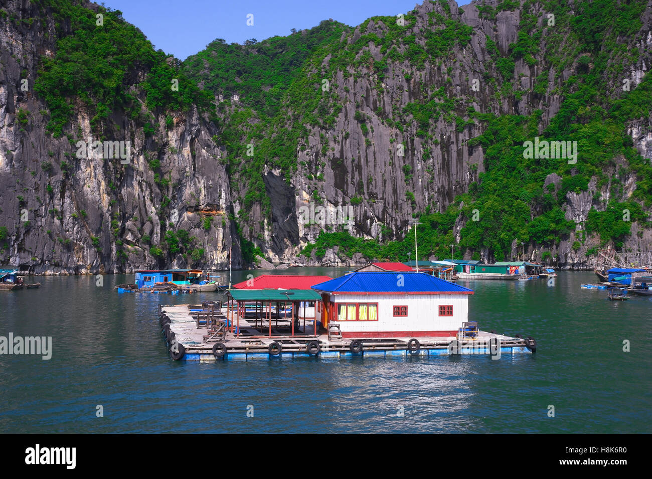 Schwimmenden Fischen Dorf und Rock Inseln in der Halong Bucht, Vietnam, Südostasien. UNESCO-Weltkulturerbe. Berglandschaft Stockfoto