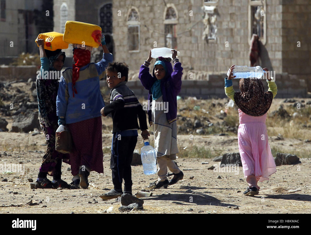 Sanaa, Jemen. 14. November 2016. Jemenitische Kinder tragen Kanister, nachdem sie sie mit sauberem Wasser zur Verfügung gestellt durch eine Aktionsgruppe in Sanaa, Jemen, am 14. November 2016 gefüllt. Der Krieg im Jemen, die mehr als 10.000 Todesopfer nach Angaben der Vereinten Nationen gefordert hat, hat eine schwere humanitäre Krise in diesem arabischen Land verursacht. © Mohammed Mohammed/Xinhua/Alamy Live-Nachrichten Stockfoto