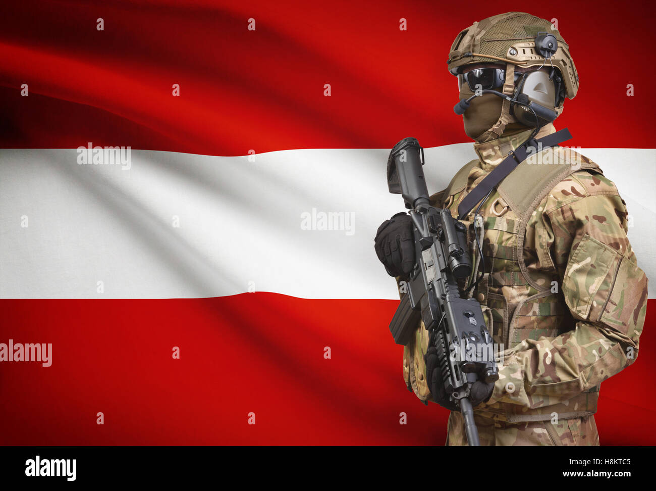 Soldat im Helm holding Maschinengewehr mit Nationalflagge auf Hintergrund - Österreich Stockfoto