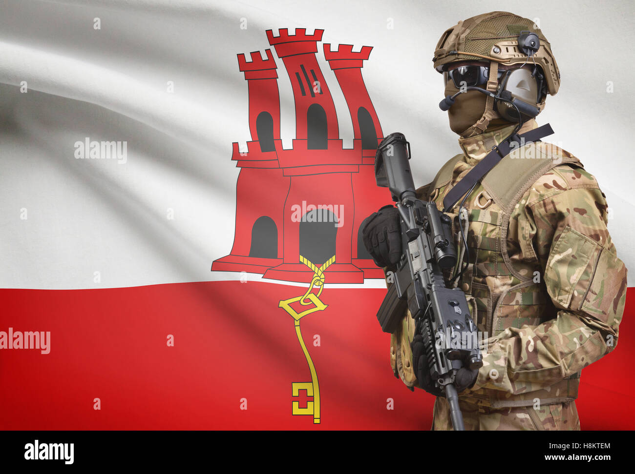 Soldat im Helm holding Maschinengewehr mit Nationalflagge auf Hintergrund - Gibraltar Stockfoto