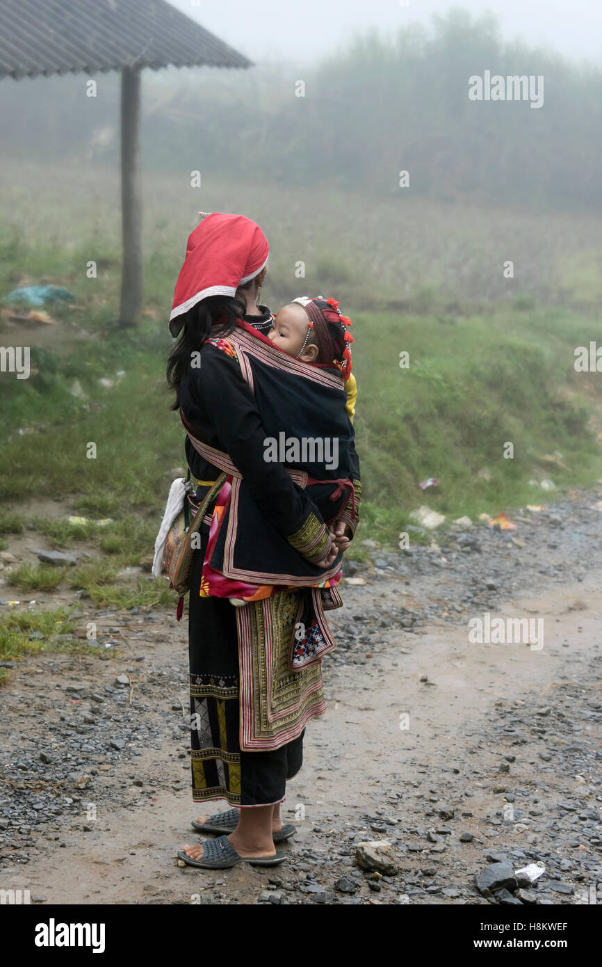 DAO Frau mit Baby, die wir auf einer nebligen Straße, Sa Pa, Nord-Vietnam Stockfoto