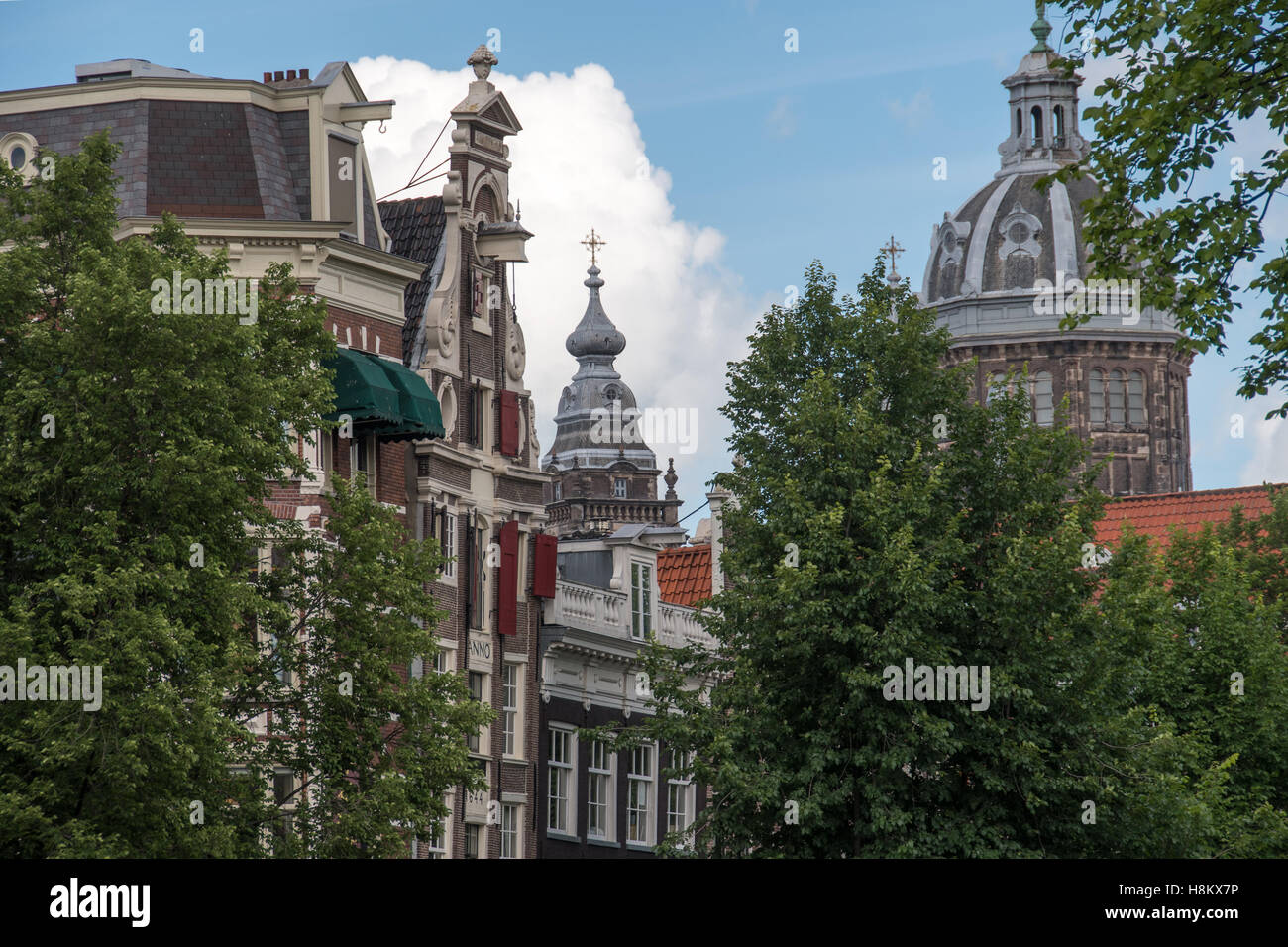 Amsterdam, Niederlande weit weg Anzeigen von St. Nikolaus-Kathedrale, hinter Bäumen und anderen Gebäuden. Stockfoto