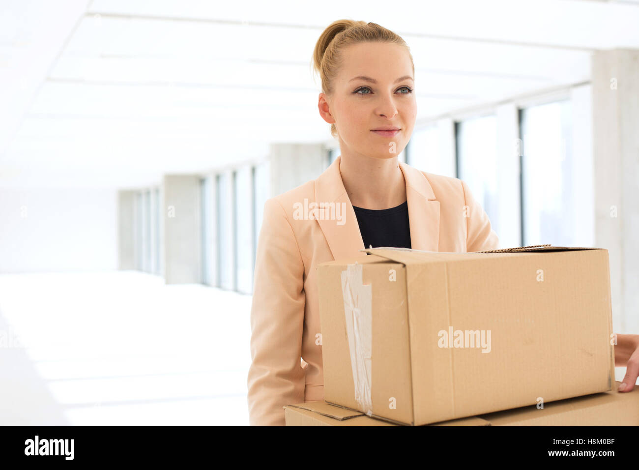 Junge Geschäftsfrau mit Pappe Boxen im neuen Büro Stockfoto