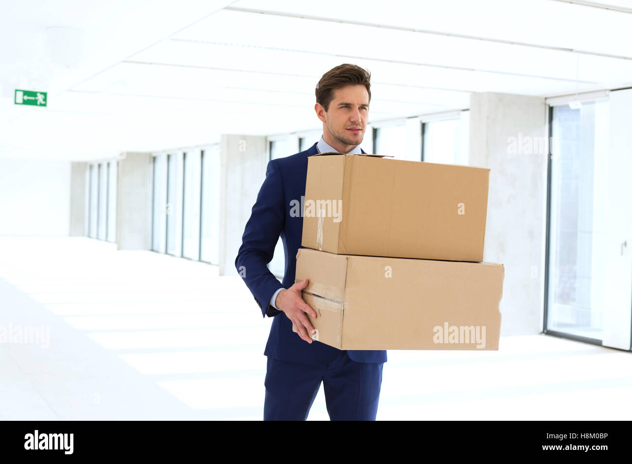 Junger Geschäftsmann mit Karton Boxen im neuen Büro Stockfoto