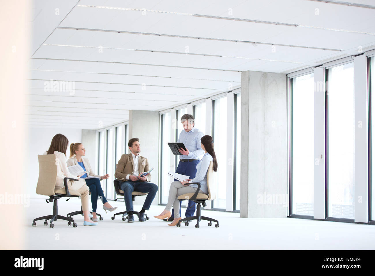 Reife Geschäftsmann mit Diskussion mit Team am Lehrstuhl für neues Büro Stockfoto