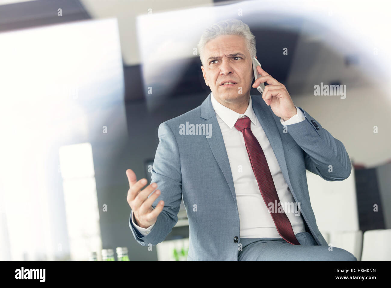 Schwere Reifen Geschäftsmann telefonieren mit Handy im Büro Stockfoto